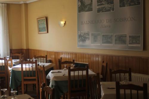 a restaurant with tables and chairs and a sign on the wall at Hotel Durtzi in Sobrón