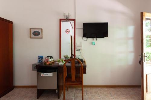 a room with a desk with a television and a chair at Kot Babi in La Digue