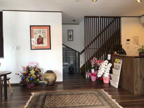 a living room with a staircase and flowers at ゲストハウス奈良庵 Nara An in Nara