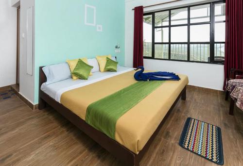 duże łóżko w pokoju z dużym oknem w obiekcie Grace Inn Munnar Homestay w mieście Munnar