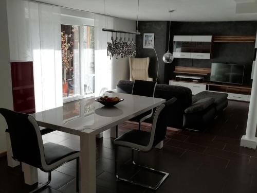 eine Küche und ein Wohnzimmer mit einem Tisch und Stühlen in der Unterkunft Ferienwohnung Lechraum in Waal in Waal