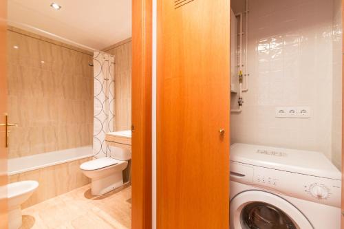 a bathroom with a washing machine and a toilet at Sweet Apartments in Sant Pere de Ribes