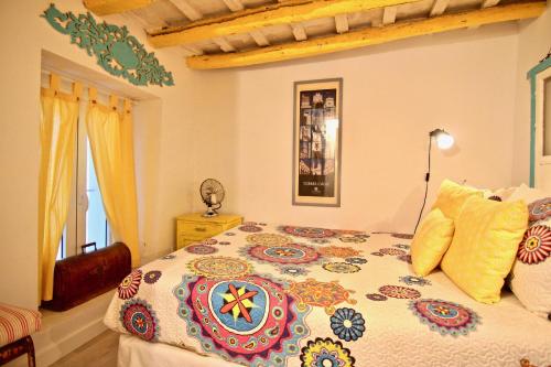 ein Schlafzimmer mit einem Bett mit einer bunten Bettdecke in der Unterkunft Loft Rincon del Artista in Cádiz