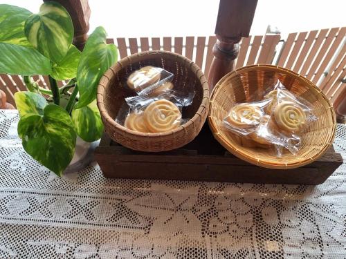 two baskets of food sitting on a table at Banthai Guesthouse in Phetchaburi
