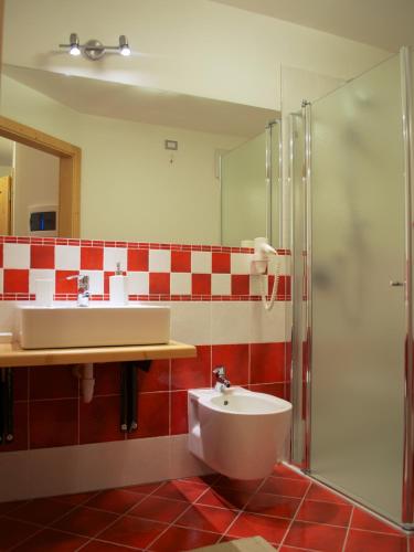 a bathroom with a sink and a shower and a toilet at Baita Scaia in Cogolo