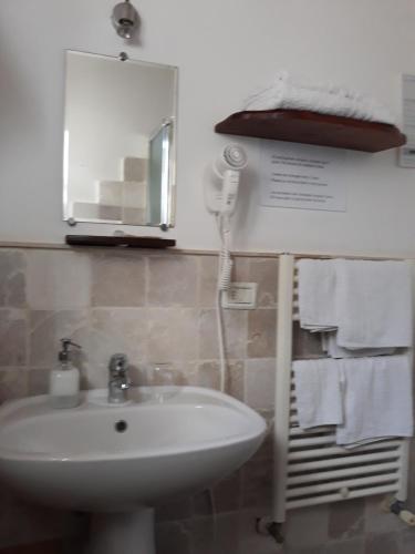 Fontana Vecchia B&B في كاستيلانا غروتي: حمام مزود بحوض غسيل ومرآة ومناشف