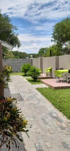 a patio with yellow tables and chairs in a yard at Riverside guesthouse B & B in Katima Mulilo