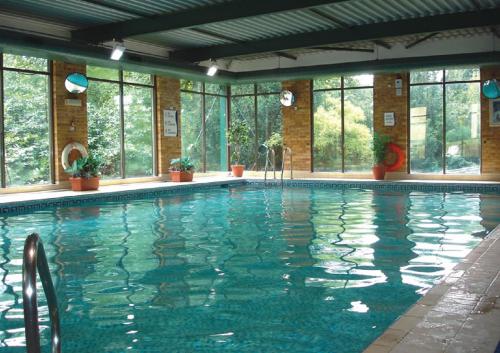 - une grande piscine dans un bâtiment doté de fenêtres dans l'établissement Britannia Leeds Bradford Airport, à Bramhope
