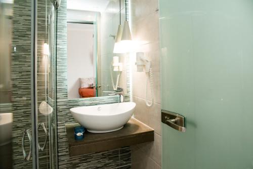 a bathroom with a sink and a glass shower at Kalidonio Studios Zante in Kalamaki