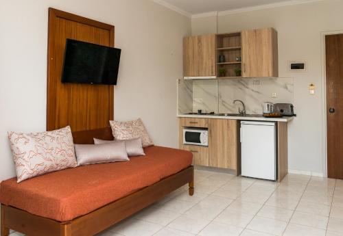 a living room with a couch and a kitchen at Kalidonio Studios Zante in Kalamaki