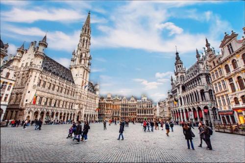 a group of people walking around a city street at Sun Hotel in Brussels