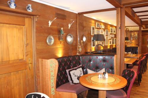 a dining room with a table and chairs and wooden walls at Hotel Schäfflerwirt in Aschheim
