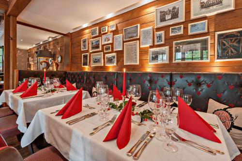 a row of tables in a restaurant with red napkins at Hotel Schäfflerwirt in Aschheim
