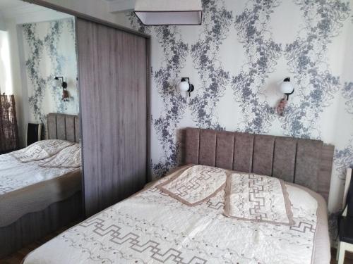 sypialnia z łóżkiem i ścianą z tapetą w obiekcie Apartment On Tavdadebuli w mieście Batumi