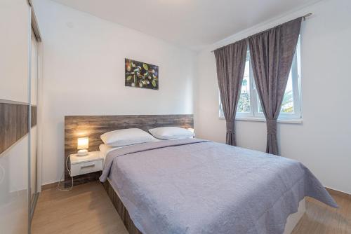 una camera con un grande letto e due finestre di Star 1 modern & centrally ap for 4 a Novalja (Novaglia)
