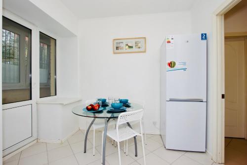 a white kitchen with a table and a refrigerator at KvartiraSvobodna Tverskaya in Moscow