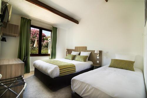 1 Schlafzimmer mit 2 Betten und einem Fenster in der Unterkunft Maison des Croisades in Aigues-Mortes