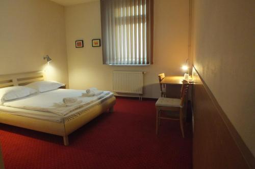 1 dormitorio con cama, escritorio y ventana en Motel Subaru en Varsovia