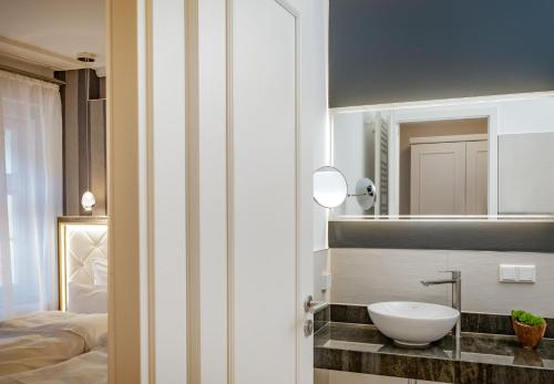 ein Badezimmer mit Waschbecken und Spiegel in der Unterkunft Sonnenresort Ettershaus in Bad Harzburg