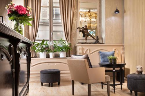 a living room with a table and chairs and a window at Grand Hotel des Balcons in Paris