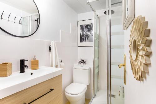 ein Badezimmer mit einem WC, einem Waschbecken und einem Spiegel in der Unterkunft Stay U-nique Apartments Ramón y Cajal in Barcelona
