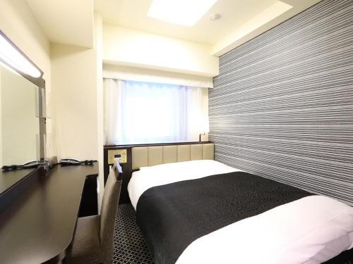東京にあるアパホテル〈御茶ノ水駅北〉のベッドと窓が備わるホテルルーム