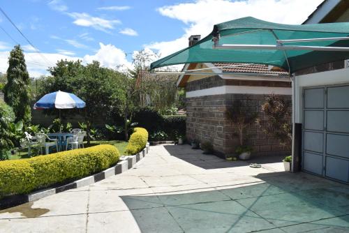 a house with a patio with an umbrella and a table at BERNKISH HOMES in Nakuru
