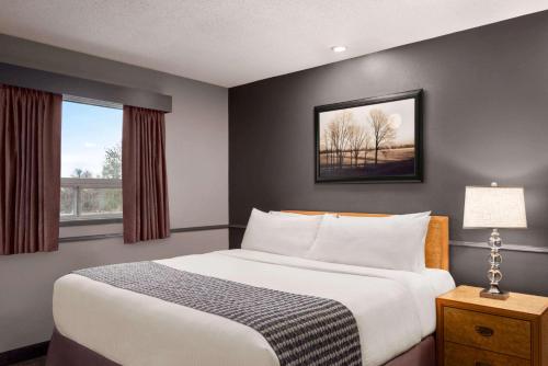 a bedroom with a large bed and a window at Travelodge by Wyndham Brandon in Brandon