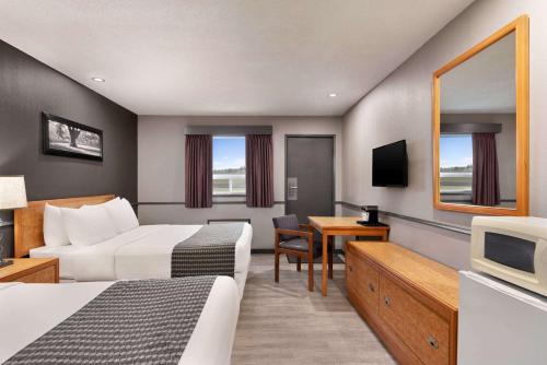 a hotel room with two beds and a television at Travelodge by Wyndham Brandon in Brandon