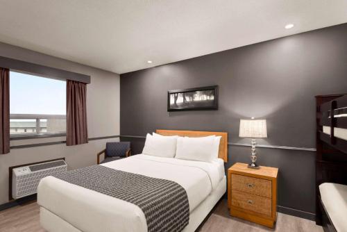 a hotel room with a bed and a window at Travelodge by Wyndham Brandon in Brandon