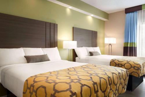 A bed or beds in a room at Baymont by Wyndham Ormond Beach