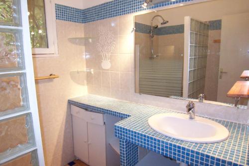 une salle de bain avec un lavabo et un miroir dans l'établissement Andre, à Porto-Vecchio