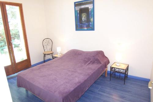 - une chambre avec un lit et une couverture violette dans l'établissement Andre, à Porto-Vecchio