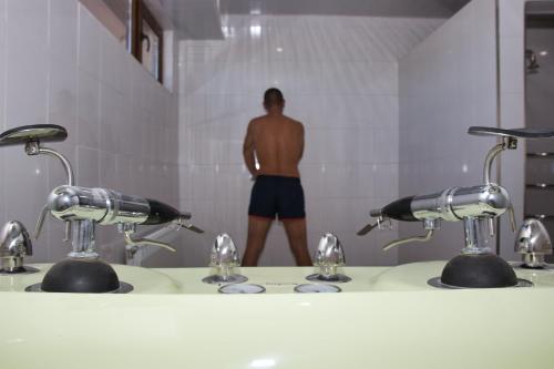 a man standing in a bathroom with two sinks at Balneo and SPA Complex MINERAL YAGODA in Yagoda