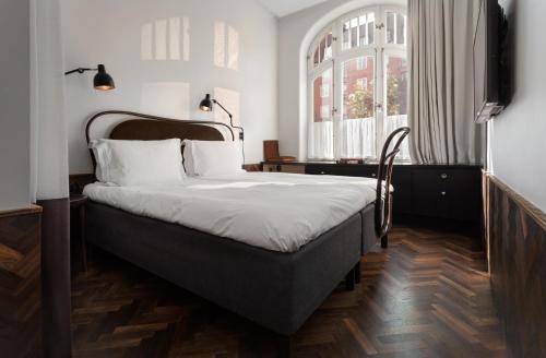 a bedroom with a bed and a large window at Miss Clara by Nobis, Stockholm, a Member of Design Hotels in Stockholm