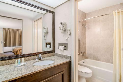 a bathroom with a sink and a toilet and a mirror at Quality Inn Suwanee I-85 in Suwanee