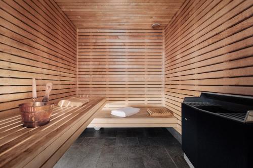 a sauna with a bench in a wooden room at Miss Clara by Nobis, Stockholm, a Member of Design Hotels in Stockholm