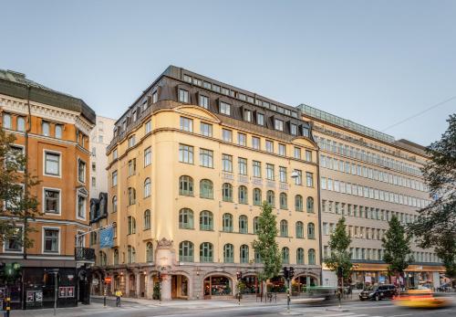 a large yellow building on a city street at Miss Clara by Nobis, Stockholm, a Member of Design Hotels in Stockholm