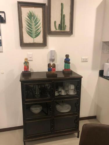 a black cabinet with dishes on it in a room at Asuncion Gracia Suites Mondrian in Asunción