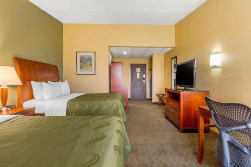 a hotel room with two beds and a flat screen tv at Quality Inn Old Saybrook - Westbrook in Old Saybrook