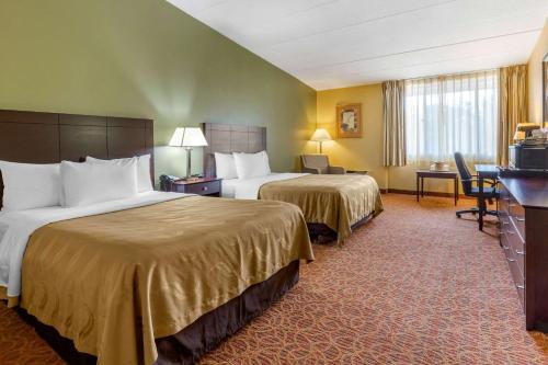 a hotel room with two beds and a desk at Quality Inn Old Saybrook - Westbrook in Old Saybrook