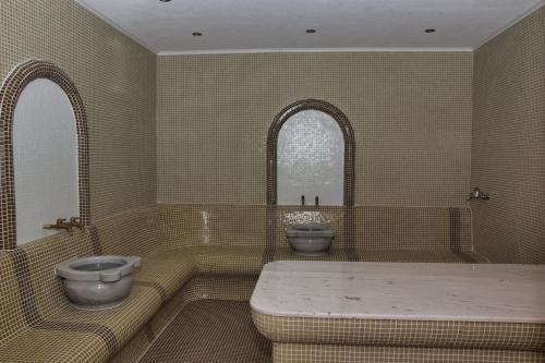 a bathroom with a tub and a toilet and a sink at Balneo and SPA Complex MINERAL YAGODA in Yagoda