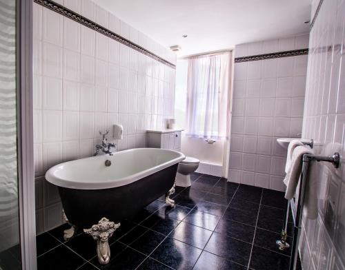 a bathroom with a large tub and a toilet at North Stafford Hotel in Stoke on Trent