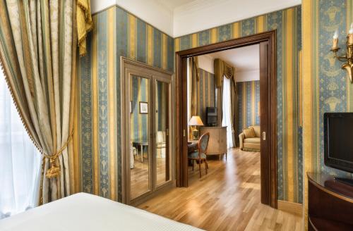 a room with blue and gold wallpaper at Sina De La Ville in Milan
