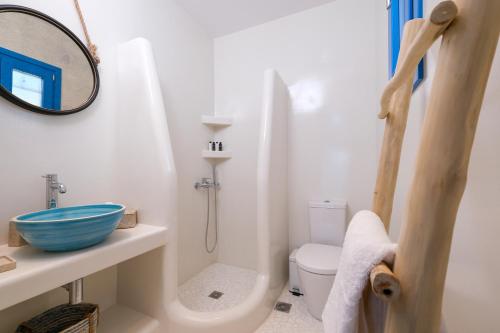 biała łazienka z toaletą i lustrem w obiekcie Aelia Collection Suites - Adults Friendly w mieście Skiros