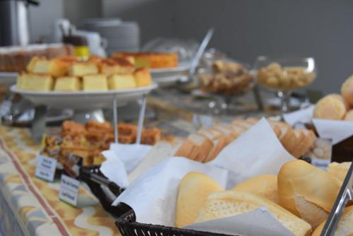 a buffet of bread and pastries on a table at Hotel Vilhar in Ivaiporã