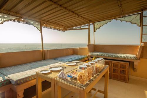 a room with a table and two beds in it at Fort Villa in Jaisalmer