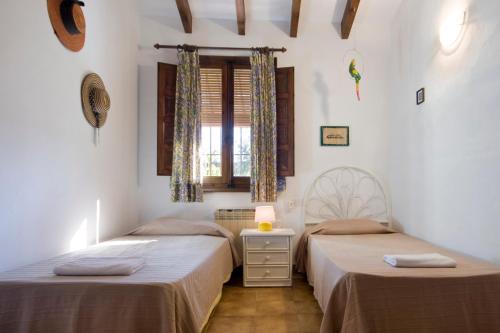 a bedroom with two beds and a window at Villa Nathalie in Jávea