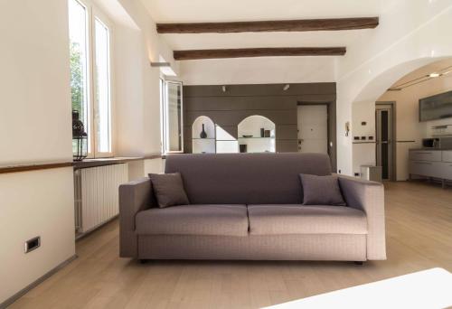 uma sala de estar com um sofá e uma cozinha em Lungolago Holiday Home - Affitti Brevi Italia em Lecco