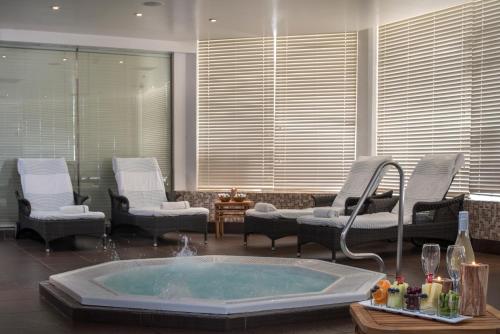 a jacuzzi tub in a room with chairs at King Solomon by Isrotel Collection in Eilat